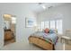Cozy bedroom featuring a window with plantation shutters, a comfy bed, and access to an ensuite bathroom at 7486 E Bajada Rd, Scottsdale, AZ 85266