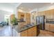 Well-lit kitchen features an island with marble countertop, natural wood cabinets, stainless steel appliances, and mosaic backsplash at 7486 E Bajada Rd, Scottsdale, AZ 85266
