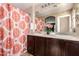 Bathroom featuring dual sinks, large mirror, and a tub with modern shower curtain at 7722 W Pipestone Pl, Phoenix, AZ 85035