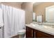A bathroom features a white shower curtain, vanity with a sink and brown cabinets at 7722 W Pipestone Pl, Phoenix, AZ 85035