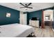 Bedroom featuring modern ceiling fan, dresser with TV, and ensuite bathroom access with hardwood style floors at 7722 W Pipestone Pl, Phoenix, AZ 85035