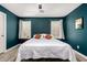 This bedroom features a queen bed, hardwood floors and plenty of natural light from the two windows at 7722 W Pipestone Pl, Phoenix, AZ 85035