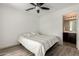 This bedroom features a ceiling fan and door to the bathroom at 7722 W Pipestone Pl, Phoenix, AZ 85035