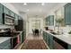 Modern kitchen with teal cabinets, stainless steel appliances, and a stylish dining area for enjoyable meals and gatherings at 7722 W Pipestone Pl, Phoenix, AZ 85035