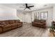 Bright living room with wood-look floors, neutral walls, comfortable seating, and a staircase, offering a comfortable living space at 7722 W Pipestone Pl, Phoenix, AZ 85035