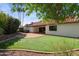 Expansive backyard with lush lawn, brick patio, and mature landscaping with hot tub at 8943 N 80Th Pl, Scottsdale, AZ 85258