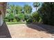 Serene backyard featuring large brick patio, lush greenery, and a neatly manicured lawn at 8943 N 80Th Pl, Scottsdale, AZ 85258
