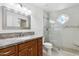Bathroom with granite countertops, wood cabinets, mosaic tile accents, and frameless glass shower at 8943 N 80Th Pl, Scottsdale, AZ 85258
