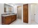 Bathroom featuring granite countertops, wood cabinets, large mirror, and a tiled shower with a glass door at 8943 N 80Th Pl, Scottsdale, AZ 85258