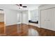 Bedroom with hardwood floors, built-in bench, and dual closets; bathroom can be seen through doorway at 8943 N 80Th Pl, Scottsdale, AZ 85258