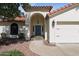Inviting front entrance featuring a bright blue door, an arched entryway, and well-maintained landscaping at 8943 N 80Th Pl, Scottsdale, AZ 85258