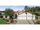 Charming home with an attached two car garage, a red tile roof, and mature landscaping at 8943 N 80Th Pl, Scottsdale, AZ 85258