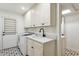Well-lit laundry room featuring modern washer/dryer, white cabinets and black and white flooring at 8943 N 80Th Pl, Scottsdale, AZ 85258