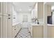 Bright laundry room featuring white cabinetry, countertops, and patterned flooring at 8943 N 80Th Pl, Scottsdale, AZ 85258