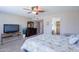 Spacious bedroom with ceiling fan, wall-mounted television, and neutral carpeting at 9128 W Kimberly Way, Peoria, AZ 85382