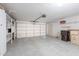 Spacious three car garage featuring epoxy floors, storage shelves, and ample room at 9128 W Kimberly Way, Peoria, AZ 85382