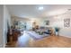 Bright living room with hardwood floors, neutral paint, comfortable furnishings, and sliding glass door to patio at 9128 W Kimberly Way, Peoria, AZ 85382