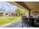 Covered patio with wicker seating area and views of the green backyard at 9128 W Kimberly Way, Peoria, AZ 85382