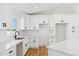 Modern kitchen featuring white cabinets, quartz countertops, black hardware, and stainless steel sink at 9280 W Wenden Dr, Arizona City, AZ 85123