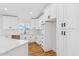 Well-lit kitchen with white cabinetry, quartz countertops, and stainless steel appliances overlooking the backyard at 9280 W Wenden Dr, Arizona City, AZ 85123