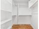 Spacious walk-in closet with built-in shelving and hardwood floors at 9280 W Wenden Dr, Arizona City, AZ 85123
