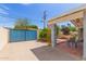 Rear yard with a covered patio and a blue privacy fence, ideal for outdoor gatherings and relaxation at 100 E Geneva Dr, Tempe, AZ 85282