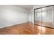 Bright bedroom features wood floors, sliding mirror closet doors, and an open doorway at 100 E Geneva Dr, Tempe, AZ 85282