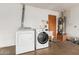 Functional laundry room features modern washer and dryer, sink, and water heater at 100 E Geneva Dr, Tempe, AZ 85282