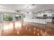 Large open living area featuring wood floors, stylish lighting, backyard access, and a kitchen at 100 E Geneva Dr, Tempe, AZ 85282