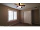 Bedroom with neutral walls, ceiling fan, window shutters, and closet at 1033 S Florence Dr, Mesa, AZ 85208