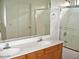 Bathroom with double sinks, wood cabinets, and a glass-enclosed shower at 10752 W Rio Vista Ln, Avondale, AZ 85323
