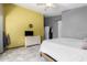 Bedroom with tiled floors, yellow accent wall, natural lighting, and closet space at 10752 W Rio Vista Ln, Avondale, AZ 85323