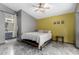 Bedroom featuring tiled floors, yellow accent wall, and an ensuite bathroom entrance at 10752 W Rio Vista Ln, Avondale, AZ 85323