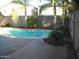Backyard with a refreshing private pool, palm trees, and a stone patio, perfect for outdoor relaxation and entertainment at 1084 E Saddleback Pl, San Tan Valley, AZ 85143