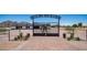 Dramatic entrance to Rancho Los Ramos with a wrought iron gate, decorative stone accents and paver entry at 10910 N Thunderbird Rd, Maricopa, AZ 85139