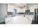 Modern kitchen showcasing white cabinetry, sleek countertops, stainless steel appliances, and stylish tile backsplash at 10910 N Thunderbird Rd, Maricopa, AZ 85139