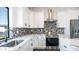 Bright kitchen with stainless steel appliances, granite countertops and black and gray mosaic backsplash at 10910 N Thunderbird Rd, Maricopa, AZ 85139