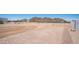 Expansive land with fencing, mountain views, and a clear blue sky perfect for developing your dream property at 10910 N Thunderbird Rd, Maricopa, AZ 85139