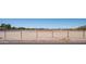 Large fenced property with a combination of natural desert landscape and distant buildings at 10910 N Thunderbird Rd, Maricopa, AZ 85139