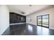 Open living room featuring polished floors, black accent wall and sliding glass doors to the backyard at 10910 N Thunderbird Rd, Maricopa, AZ 85139