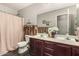 Bathroom featuring a double sink vanity with a framed mirror and a shower with curtain at 12041 W Melinda Ln, Sun City, AZ 85373
