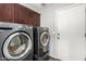Convenient laundry room with modern washer and dryer units and storage cabinets at 12041 W Melinda Ln, Sun City, AZ 85373