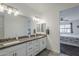 Bright primary bathroom with granite counters, dual sinks, and a glimpse into the bedroom at 12048 E Chevelon Trl, Gold Canyon, AZ 85118