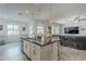 Open kitchen features a granite island with seating, stainless steel appliances, and seamless flow into the living area at 12048 E Chevelon Trl, Gold Canyon, AZ 85118