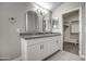 Bathroom featuring double vanity with granite countertops and modern fixtures and ensuite closet at 12543 W Roanoke Ave, Avondale, AZ 85392