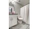 Bathroom features a modern vanity with a granite countertop, complemented by a shower with white curtain at 12543 W Roanoke Ave, Avondale, AZ 85392