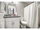 Bathroom features a modern vanity with a granite countertop, complemented by a shower with white curtain at 12543 W Roanoke Ave, Avondale, AZ 85392
