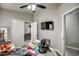 Bright bedroom featuring a ceiling fan and a television, bathed in natural light from the doorway at 12543 W Roanoke Ave, Avondale, AZ 85392