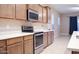 Well-equipped kitchen showcasing stainless steel appliances, wooden cabinetry and white countertops at 1255 N Arizona Ave # 1216, Chandler, AZ 85225