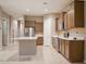 Open-concept kitchen featuring wooden cabinets, stainless steel appliances, an island, and tile flooring at 1255 N Arizona Ave # 1216, Chandler, AZ 85225